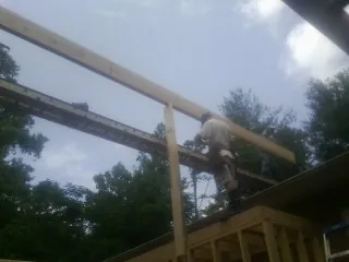 Carpenter setting a ridge beam over a new addition frame — Ice Dam Removal by Roofing Brothers in Staples